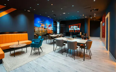 Escape Hunt Dubai lounge area with seating and game tables for Curse of the Pharaoh Escape Room.