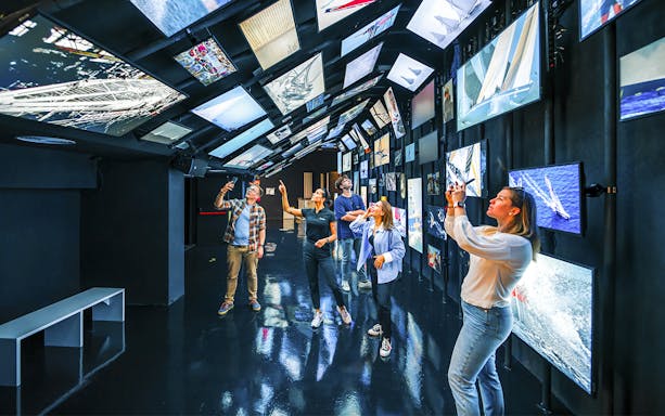 Visitors explore interactive sailing exhibits at the America's Cup 360 experience.