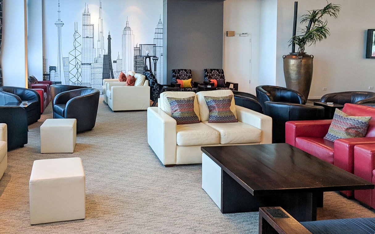Plaza Premium Lounge seating area with modern decor and city skyline mural.