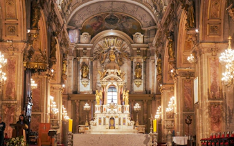 Interior of Santiago Metropolitan Cathedral with ornate altar and chandeliers in Santiago, Chile.
