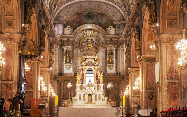 Interior of Santiago Metropolitan Cathedral with ornate altar and chandeliers in Santiago, Chile.