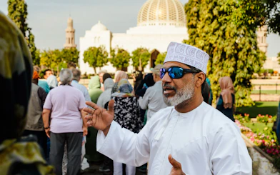 Guide explaining to tourists at Sultan Qaboos Grand Mosque, Oman.