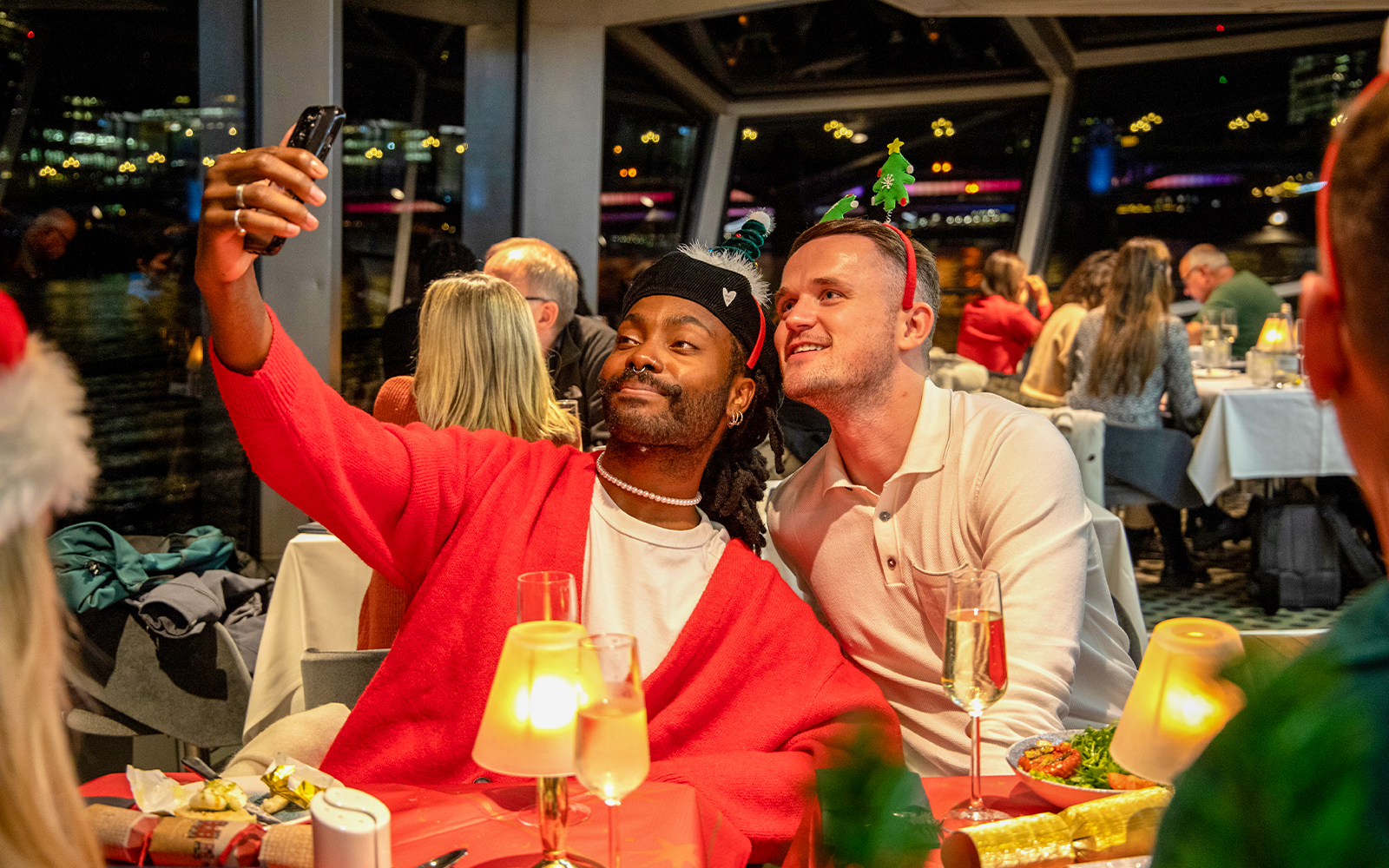 Guests taking a selfie at a Christmas dinner party on a Thames River cruise.