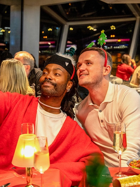 Guests taking a selfie at a Christmas dinner party on a Thames River cruise.
