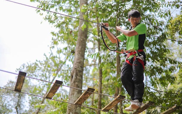 Participant crossing a rope bridge at SKYTREX Adventure Sungai Congkak, Kuala Lumpur.