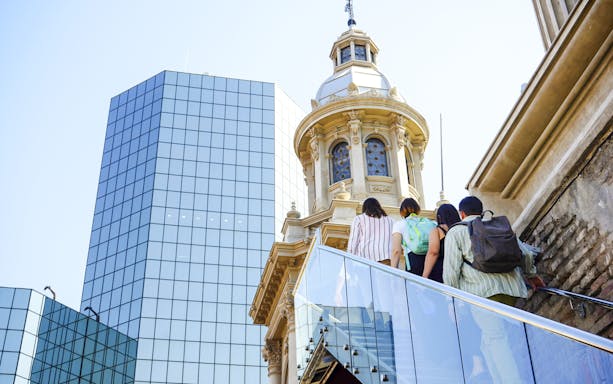 Guests ascending stairs with guide at Santiago Cathedral Bell Tower.