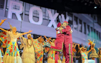 Performers in vibrant costumes on stage at Roxy Dinner Show, Rio de Janeiro.