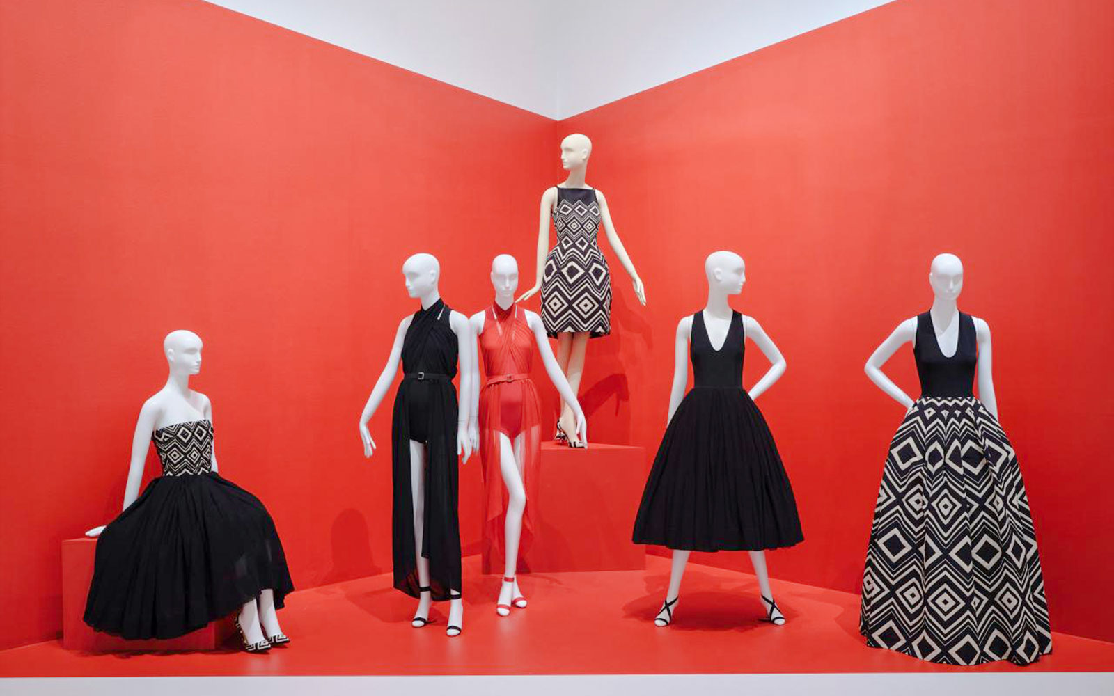 Mannequins displaying geometric-patterned dresses at Martin Grant Exhibition.