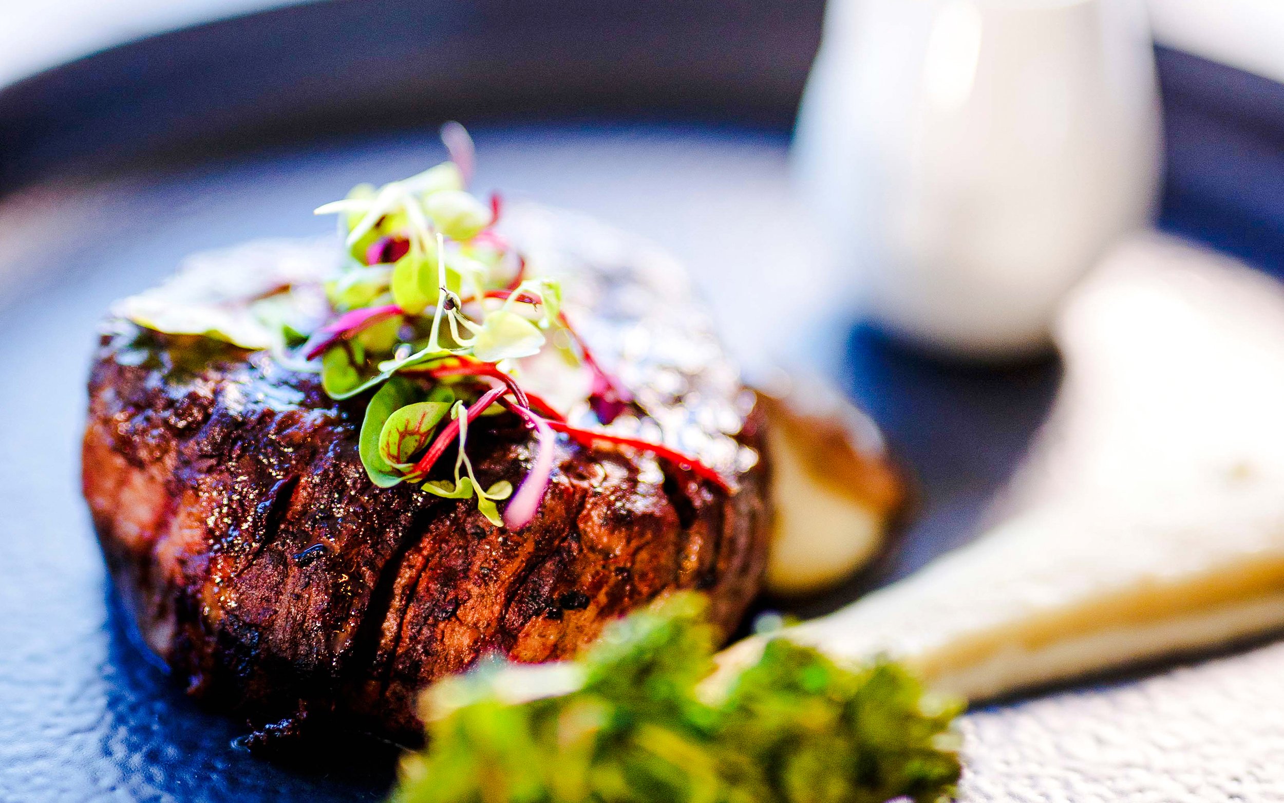 Steak with microgreens served on a plate during Vivid Sydney Sunset Cruise.