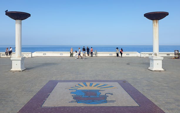 Seaside promenade in Tangier with people enjoying ocean views.