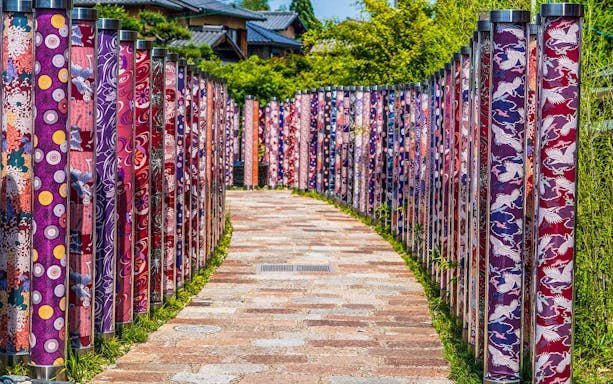 Colorful kimono forest path in Arashiyama, Kyoto, part of Sagano Bamboo Grove tour.