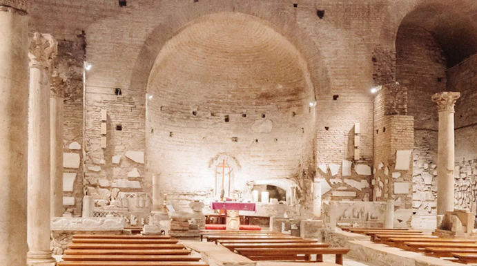 Interior of the Catacombs of Domitilla with stone benches and altar.