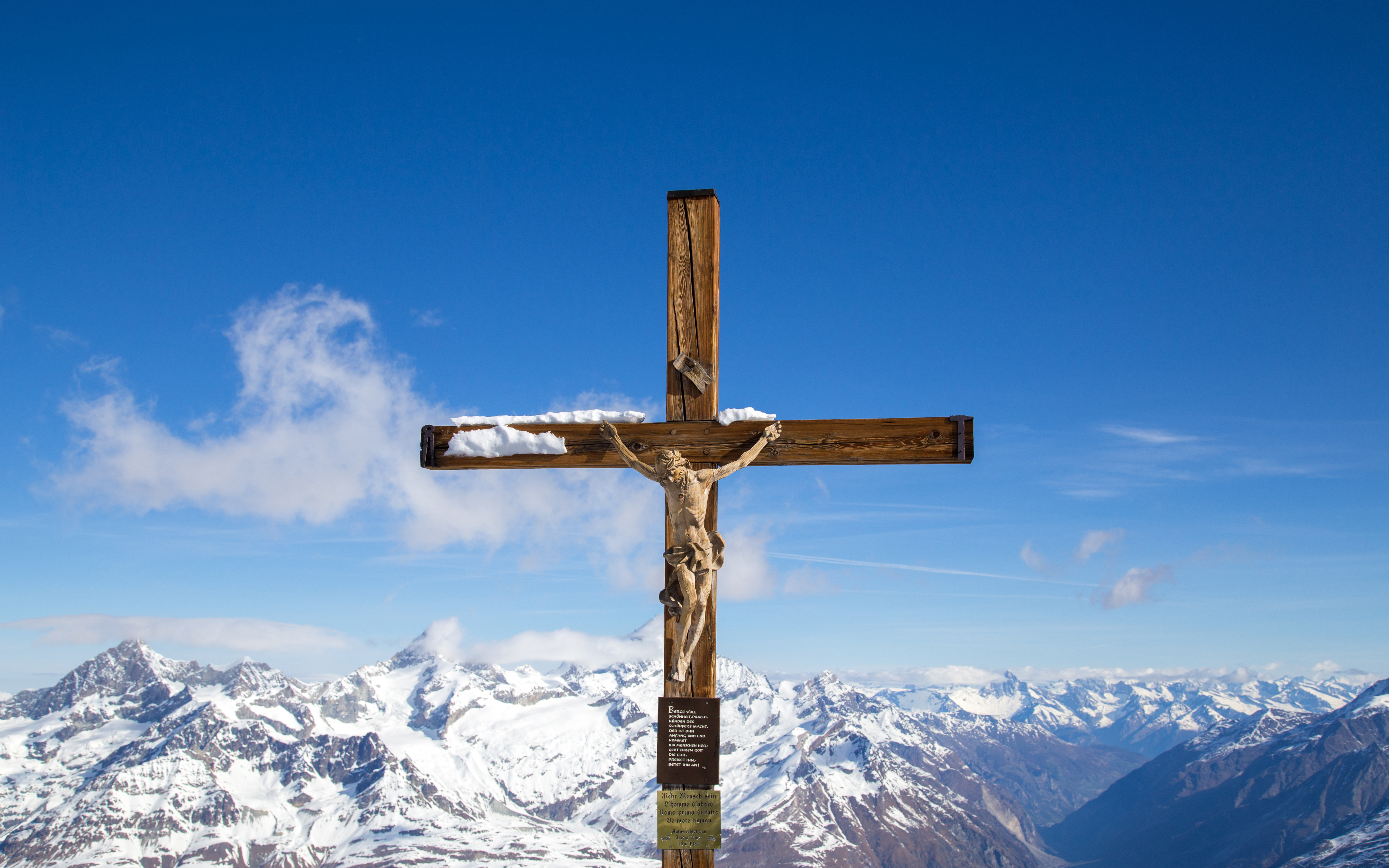Crucifix at Matterhorn Glacier Paradise with snow-covered Alps in the background.