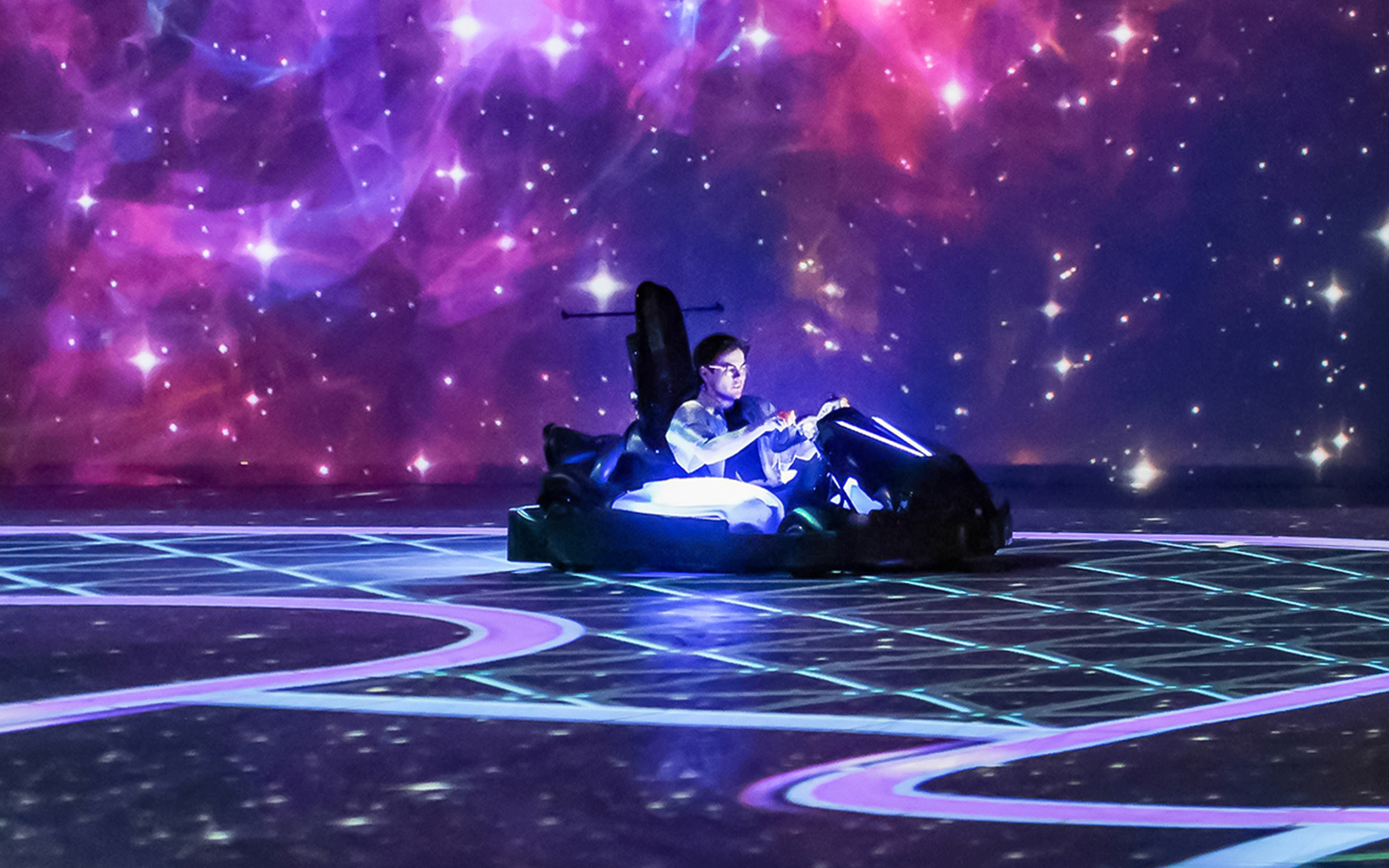 Kart racer in neon-lit track at Chaos Karts Dubai immersive experience.