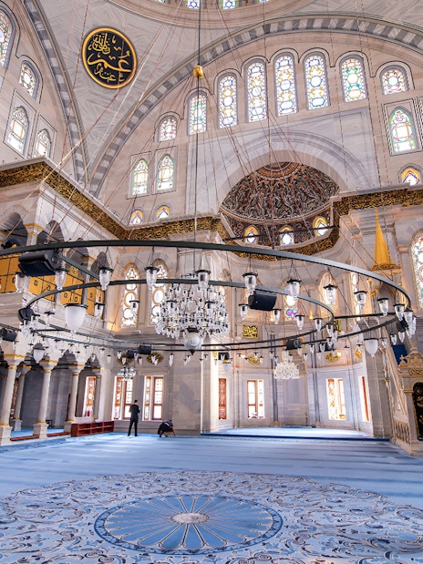 Interior view of the Blue Mosque with ornate chandeliers and stained glass windows.