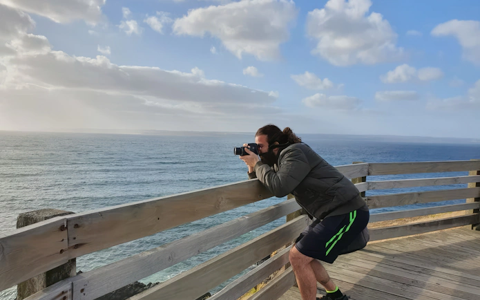 Photographer capturing ocean view from Phillip Island boardwalk.