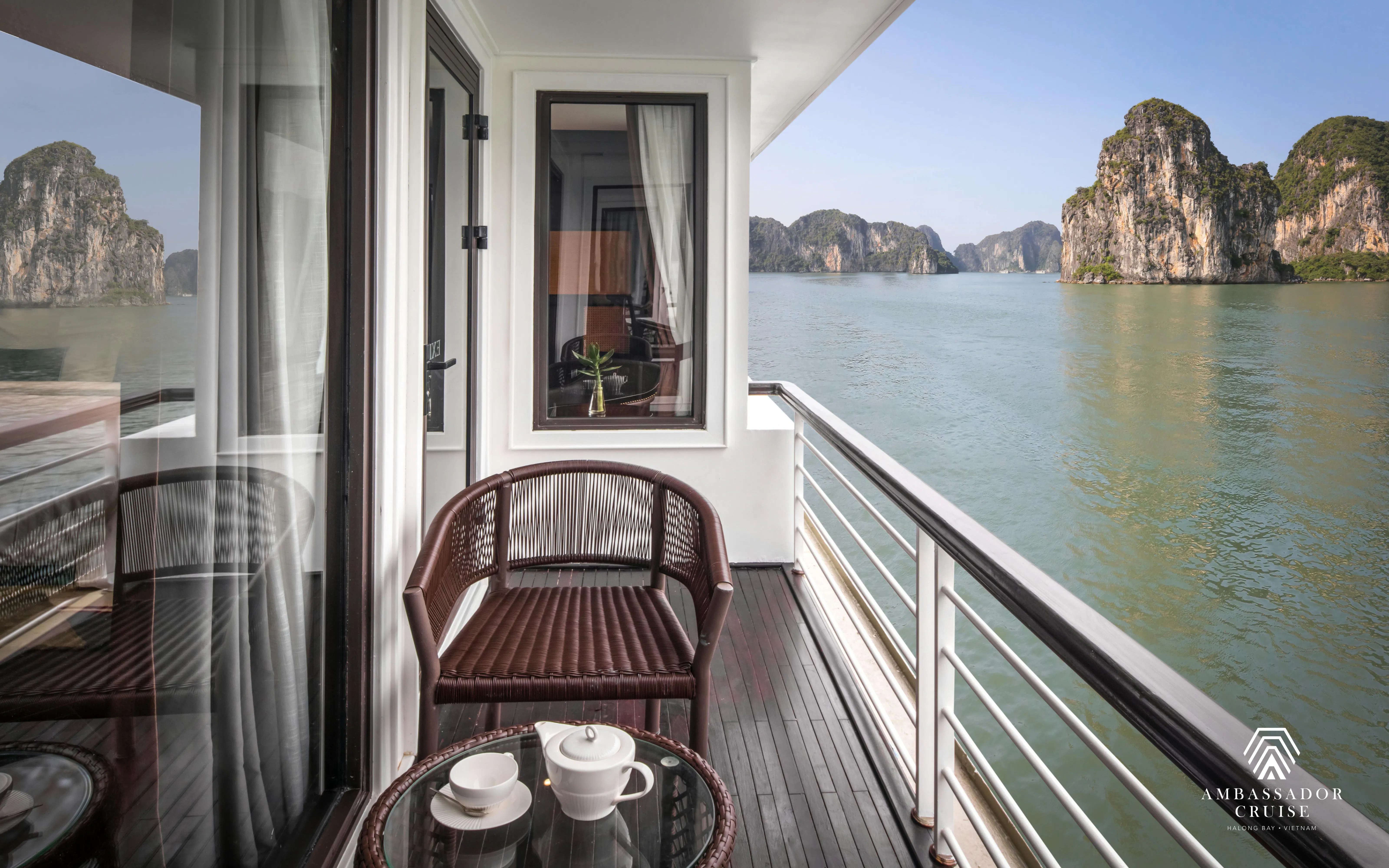 Private balcony view of Ha Long Bay from 5-star Ambassador Cruise, featuring limestone karsts.