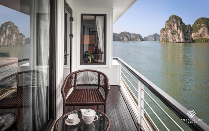 Private balcony view of Ha Long Bay from 5-star Ambassador Cruise, featuring limestone karsts.