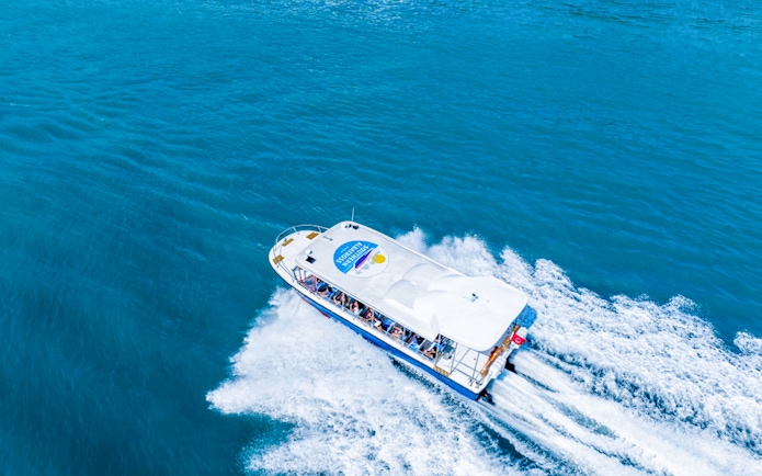 Tour boat cruising on blue waters, part of Combo Mega Adventure in Singapore.