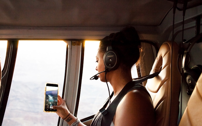 Guest viewing Grand Canyon from airplane window on South Rim tour.