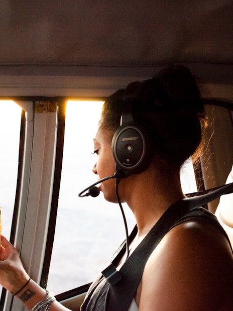 Guest viewing Grand Canyon from airplane window on South Rim tour.