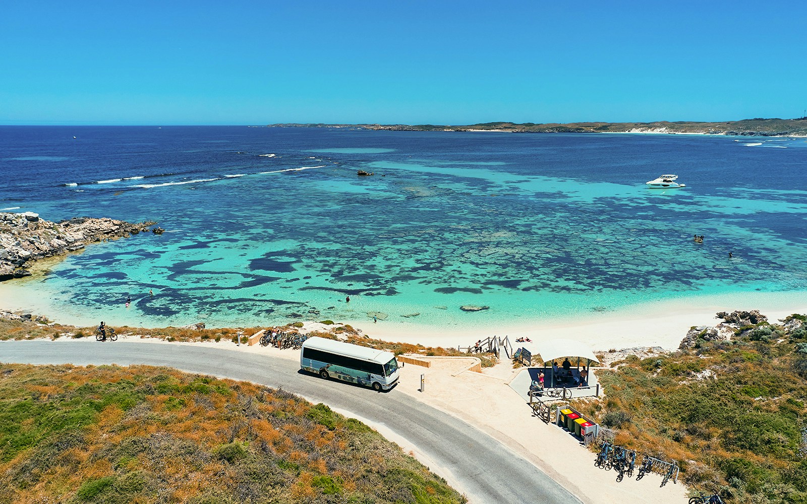 Tourists enjoying the Rottnest Island Ferry and Adventure Boat Tour, departing from Perth or Fremantle, with a view of the island's coastline
