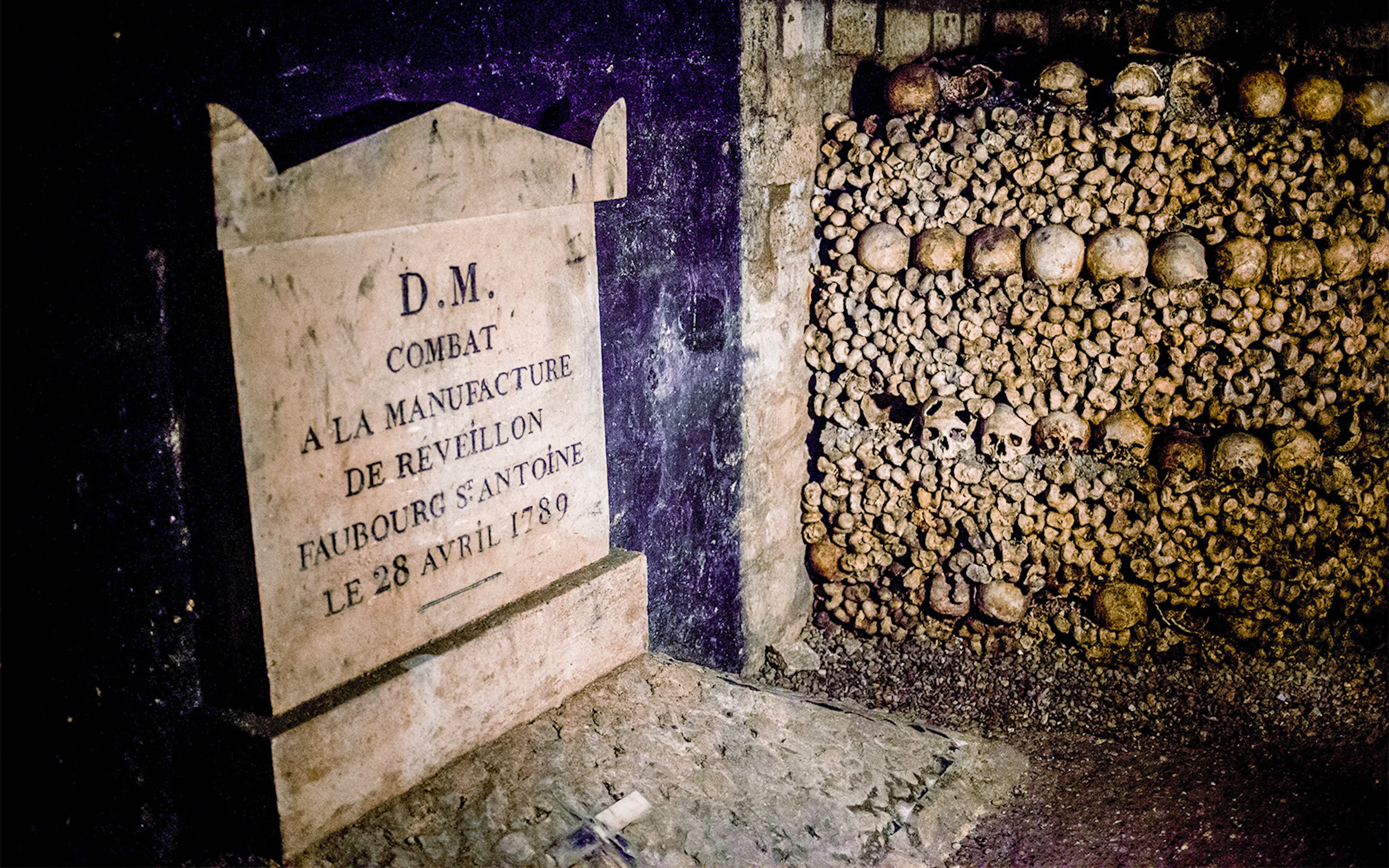 Stone plaque and skulls in the Paris Catacombs, France.