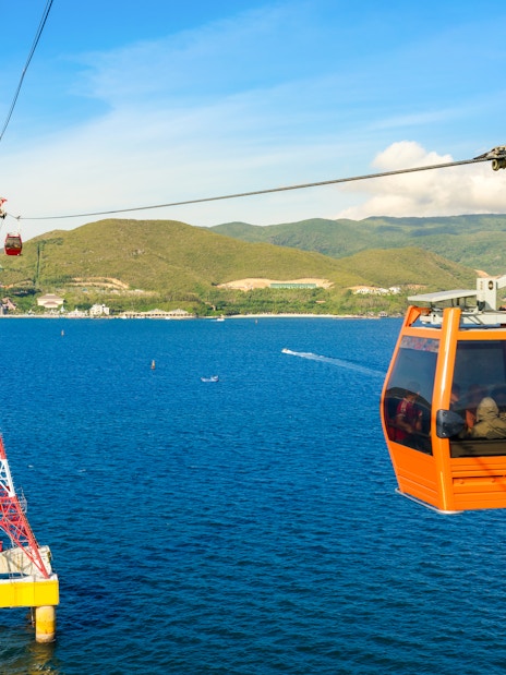 Cable car over ocean to Vinpearl, Nha Trang with mountains in background.