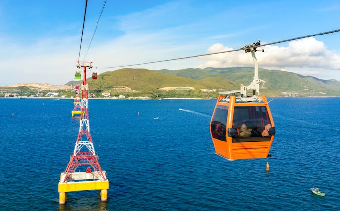 Cable car over ocean to Vinpearl, Nha Trang with mountains in background.