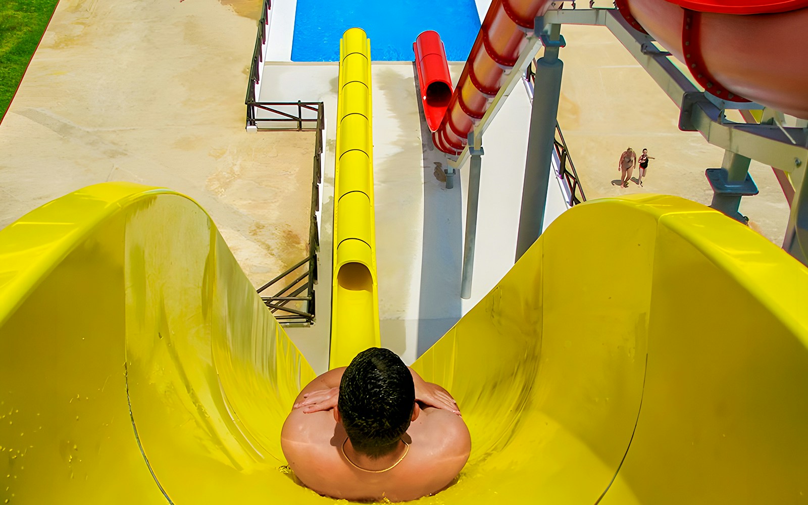 Person sliding down the yellow speed race slide at Aquopolis Torrevieja.