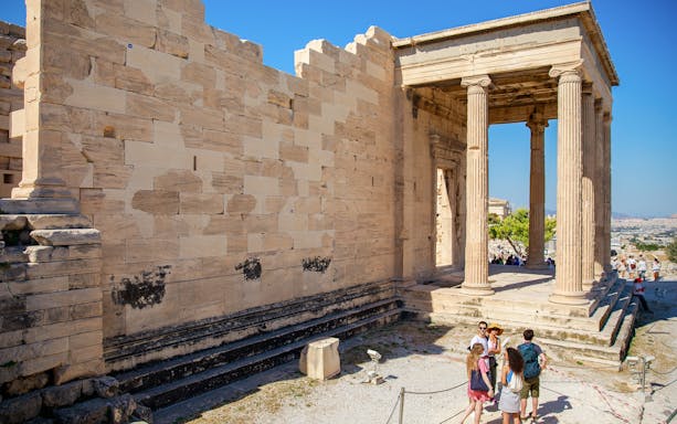 Visitors exploring the Erechtheion temple on the Acropolis in Athens, Greece.