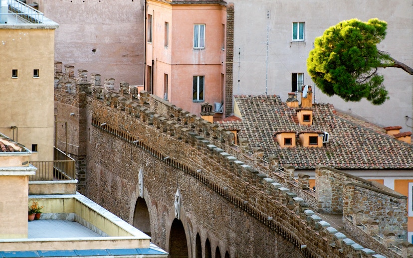 Passetto di Borgo stone wall with arches and adjacent buildings in Rome.