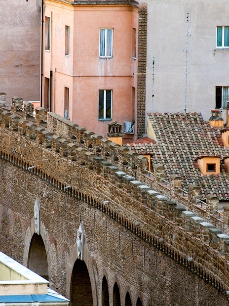 Passetto di Borgo stone wall with arches and adjacent buildings in Rome.