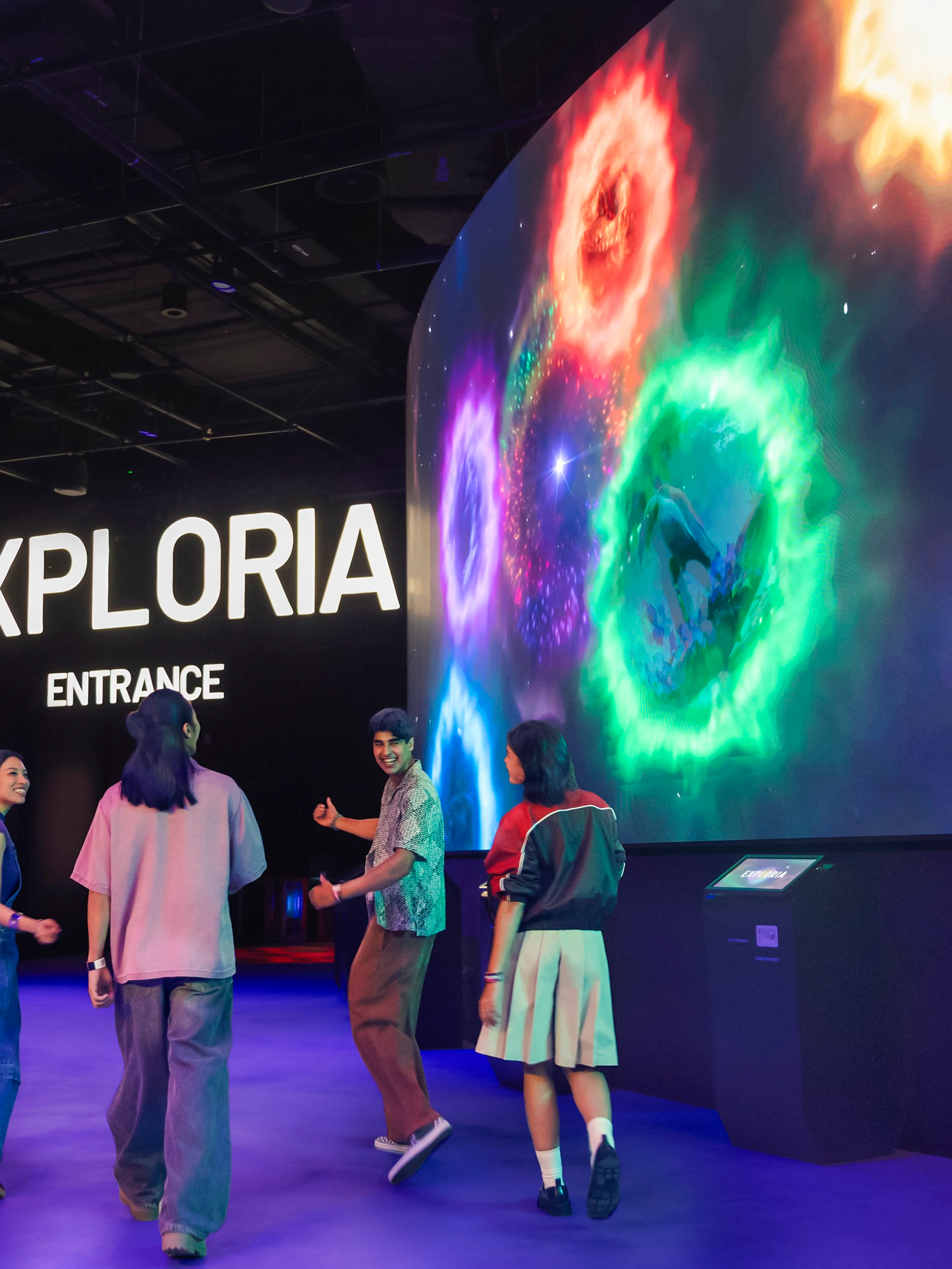 Visitors at Exploria entrance, Mandai Wildlife, viewing interactive cave spider exhibit displays.