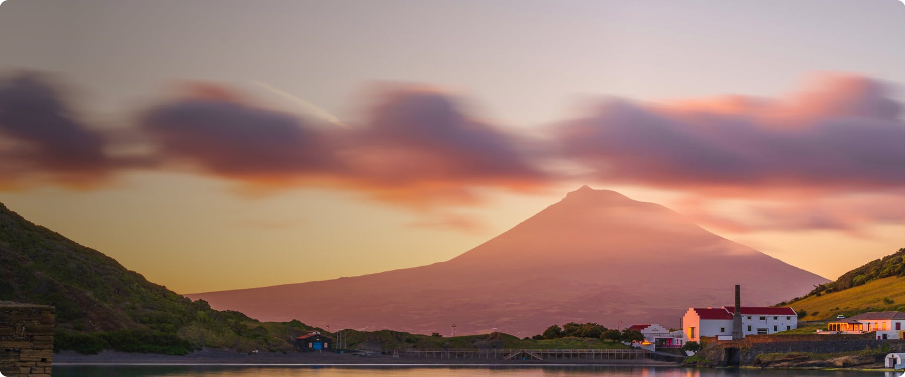 Pico mountain view with lush greenery and ocean in the Azores, Portugal.