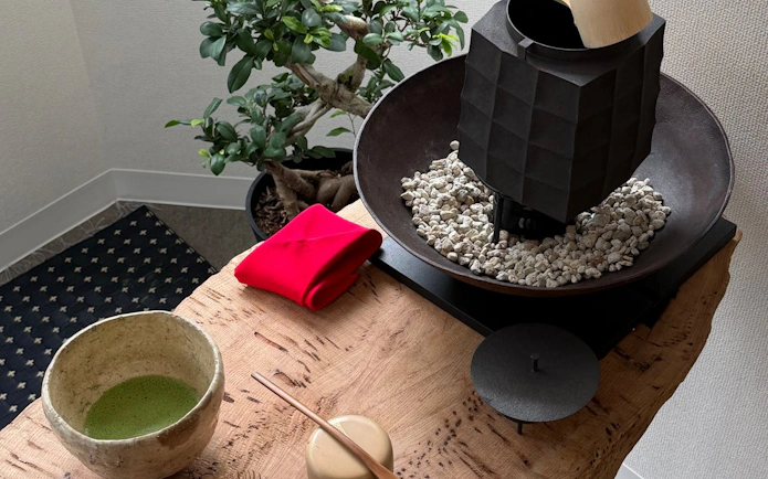 Matcha tea and pottery tools on a wooden table at a Kintsugi workshop in Shibuya.