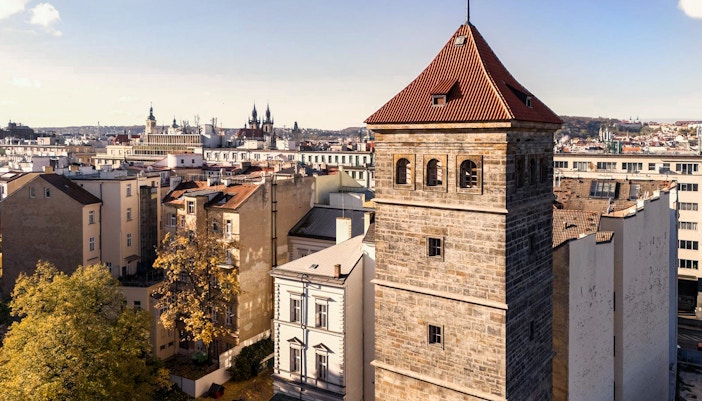 New Mill Water Tower in Prague with cityscape in the background.