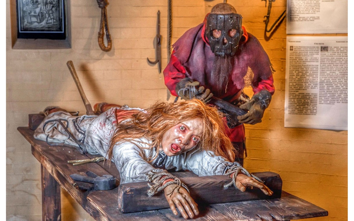 Medieval Torture Museum exhibit with a mannequin on a rack and a masked figure.