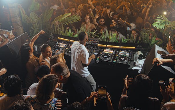 DJ performing at Club Chinois, Ibiza with crowd enjoying the music.