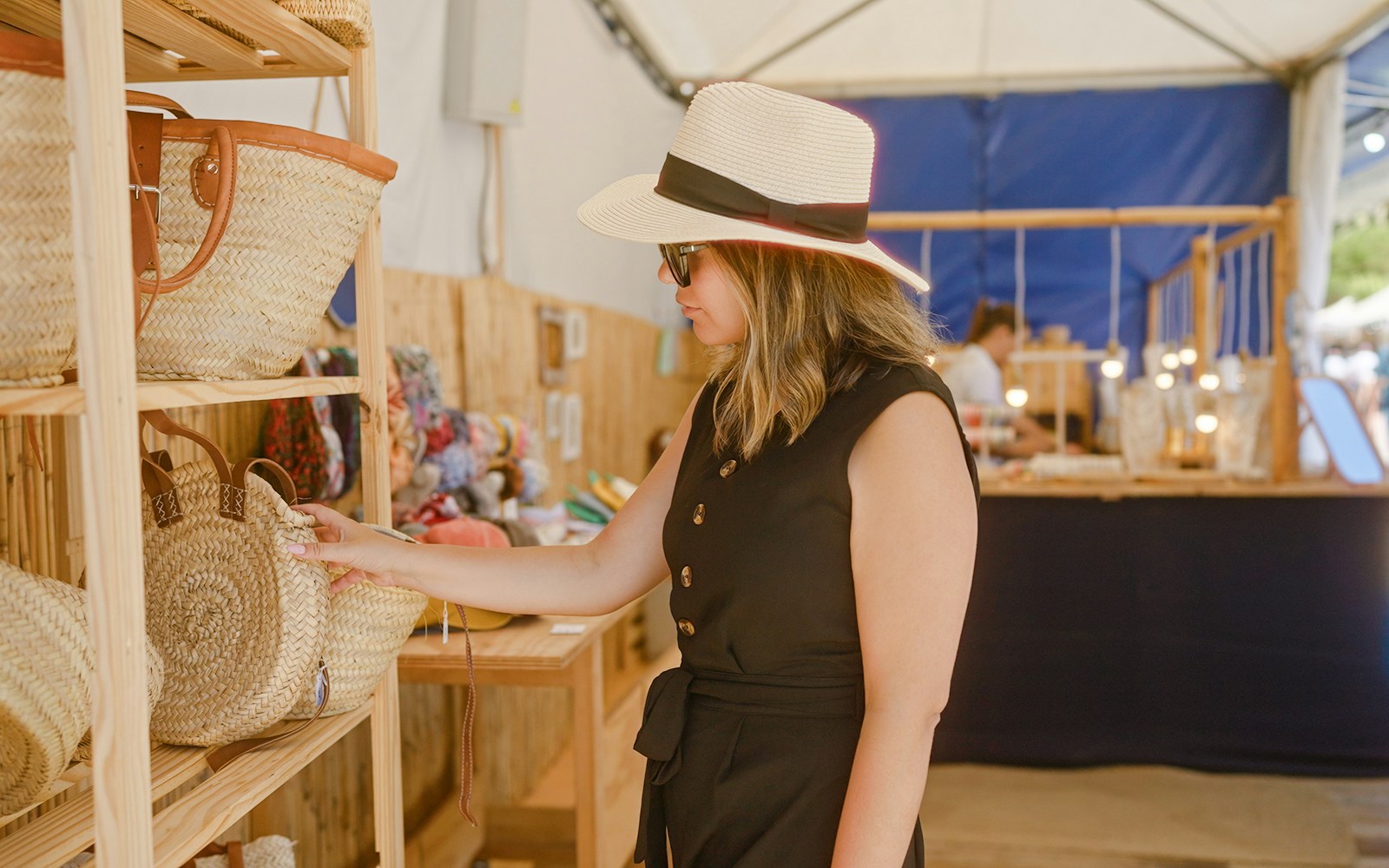 Woman browsing woven baskets at a market in Tenerife.