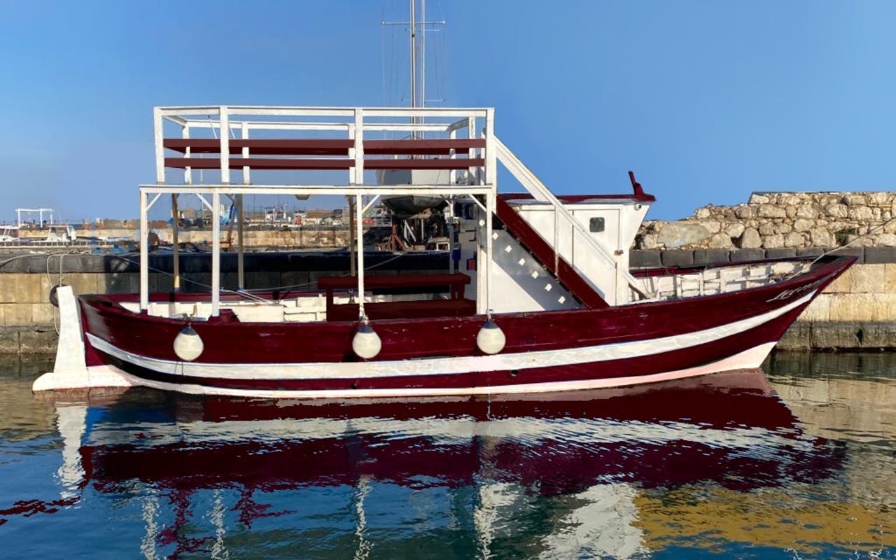 Boat docked at Ortigia harbor for sunset tour with aperitif.
