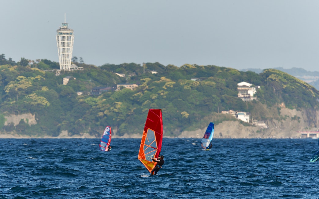 Windsurfers near Enoshima Island with Enoshima Sea Candle in the background.