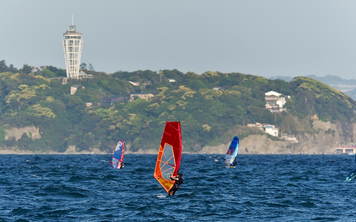 Windsurfers near Enoshima Island with Enoshima Sea Candle in the background.