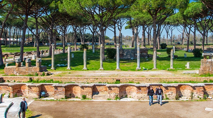 Ancient Roman theater ruins surrounded by trees in Ostia Antica, Rome.