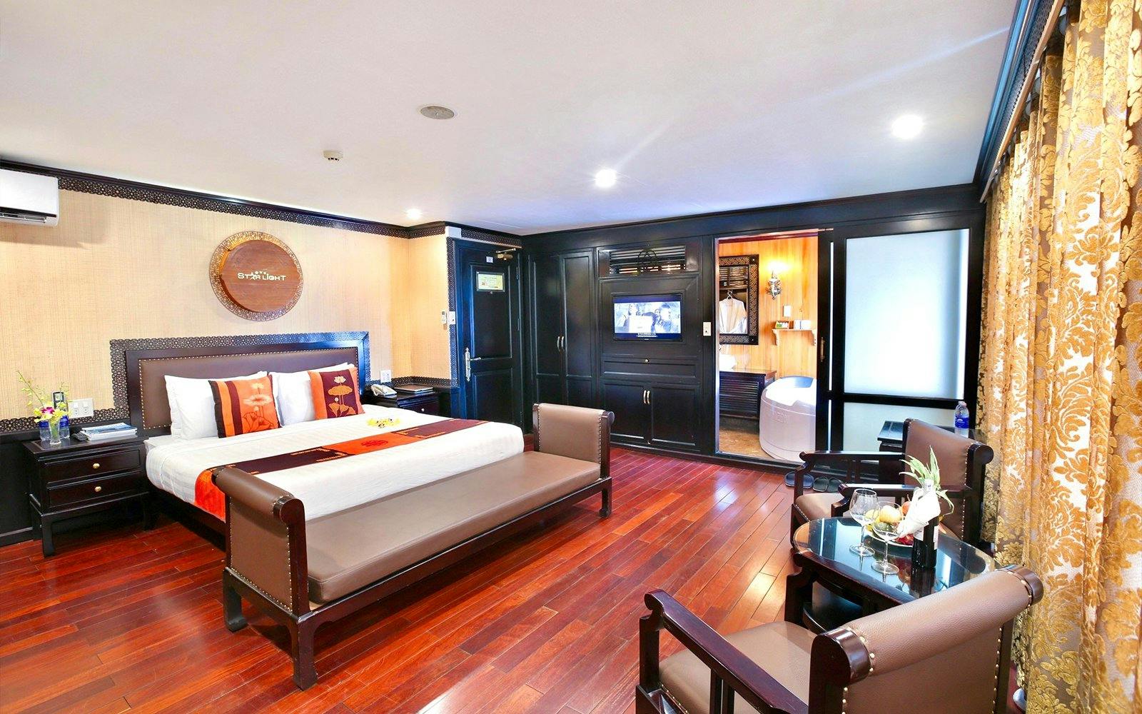 Luxurious cabin interior on a 5-star cruise in Halong Bay, featuring a king-size bed and private bathroom.
