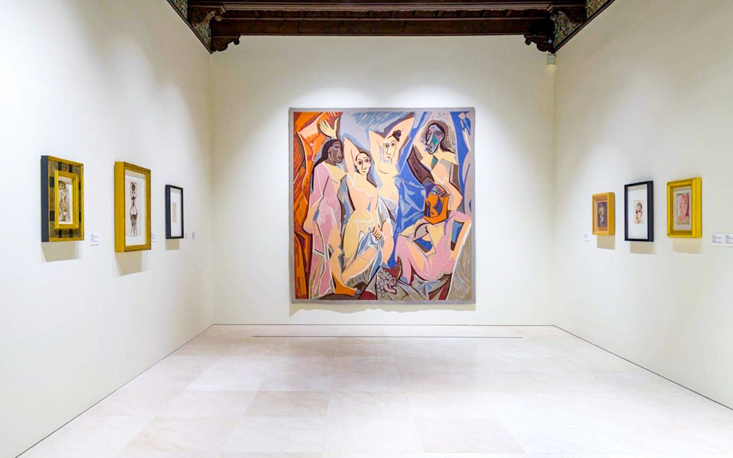 Artworks displayed at the Picasso Museum in Malaga, featuring a large central painting.