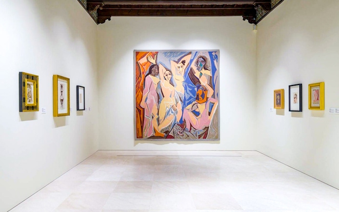 Artworks displayed at the Picasso Museum in Malaga, featuring a large central painting.