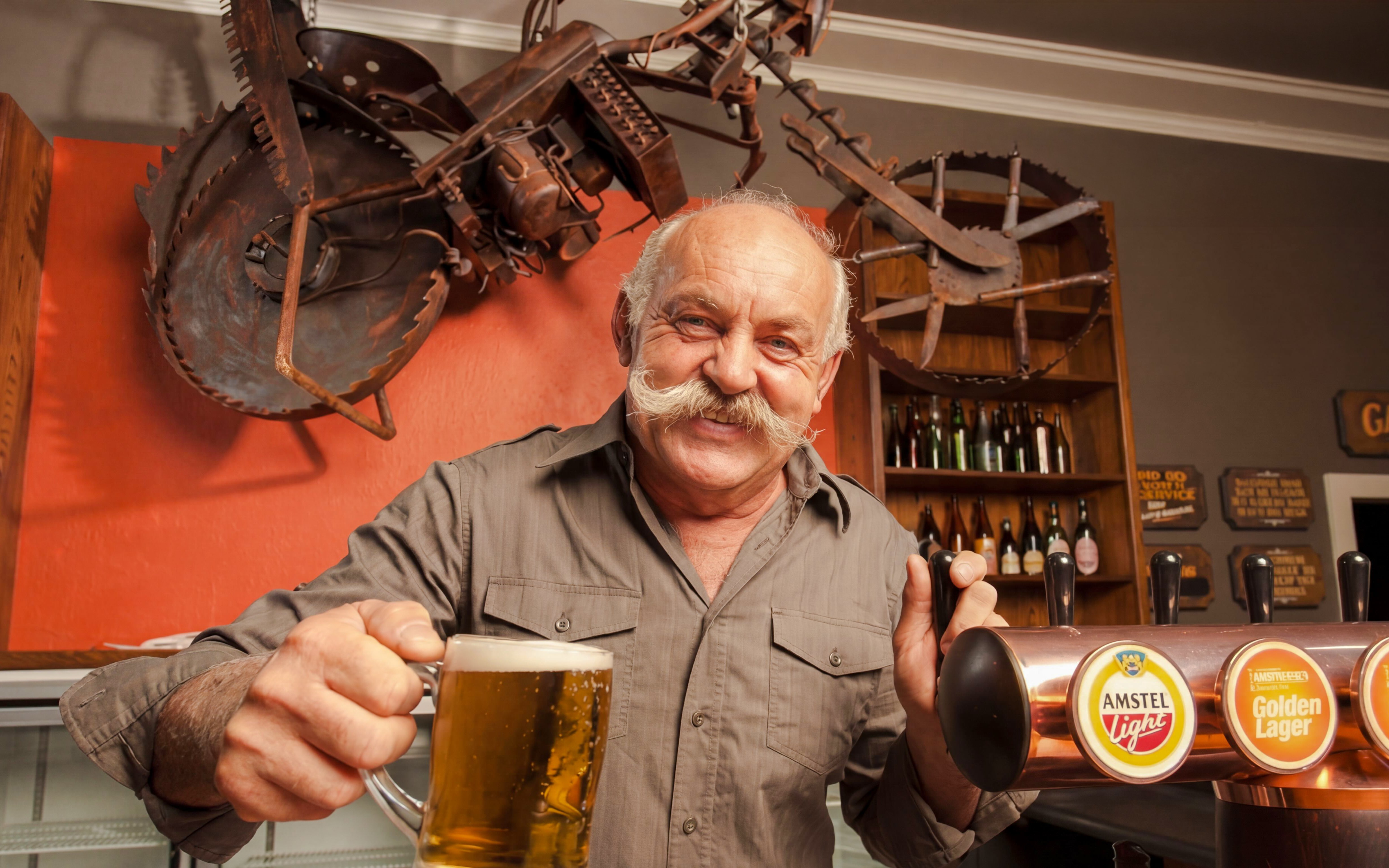 Man serving beer at Riverhead Tavern during scenic boat cruise.