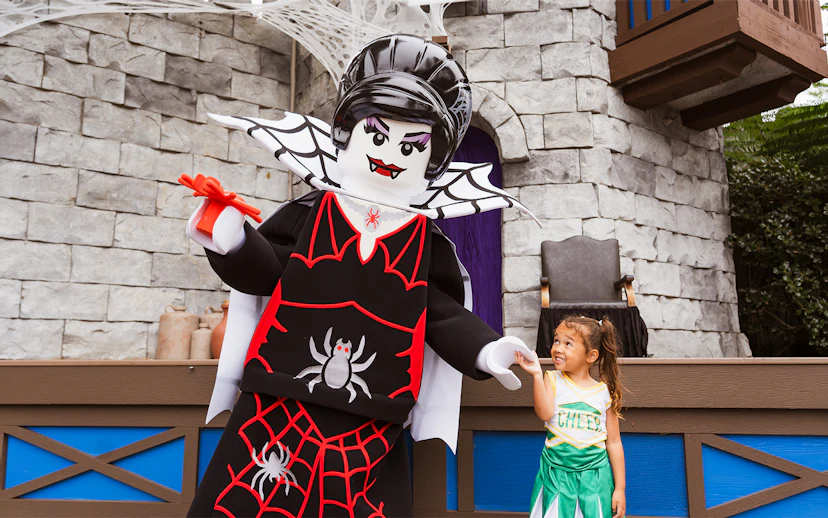 SpiderLady character at Brick or Treat event, Legoland Florida, interacting with a child.