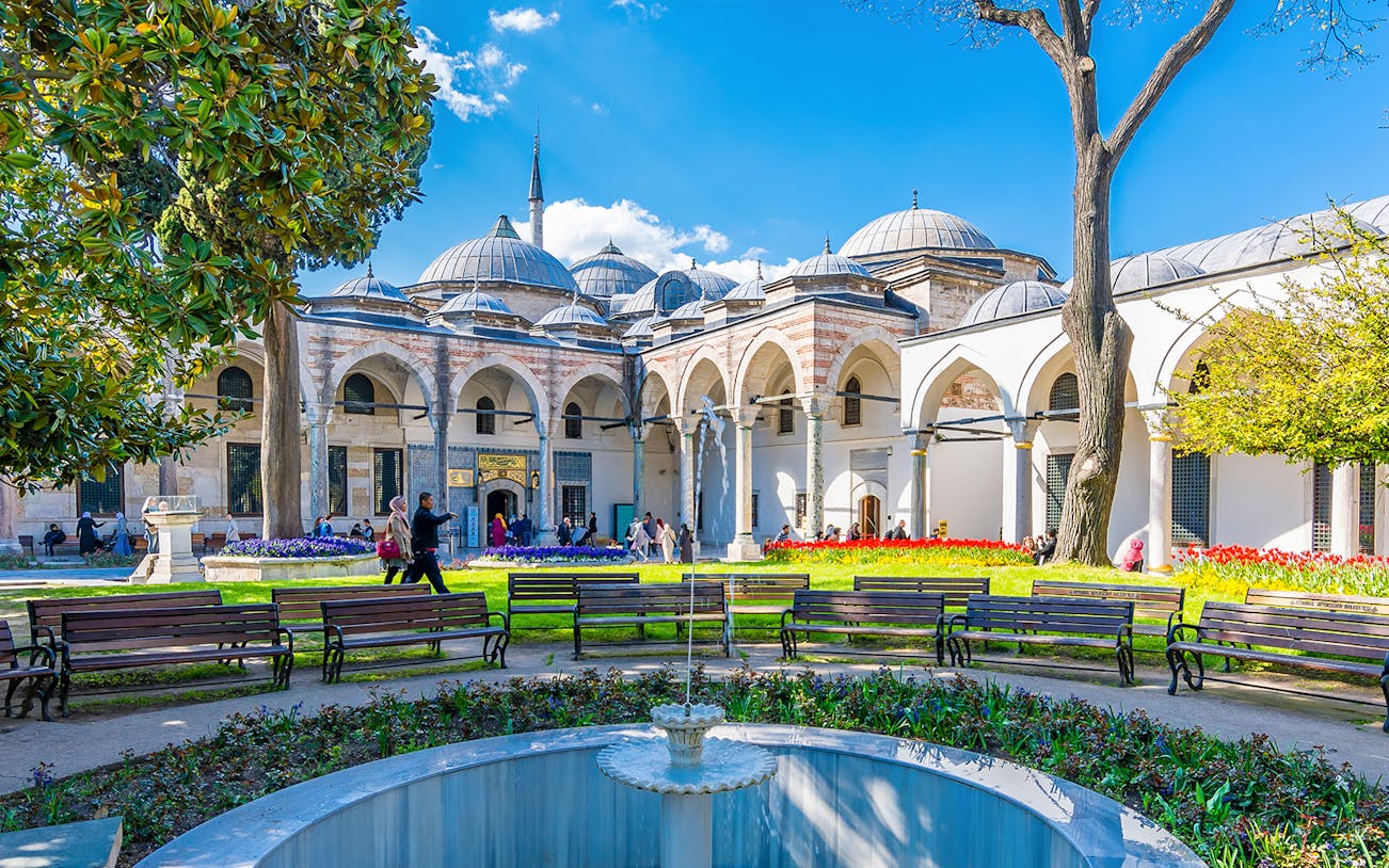 Topkapi Palace Courtyard with fountain, benches, and arched colonnade in Istanbul.